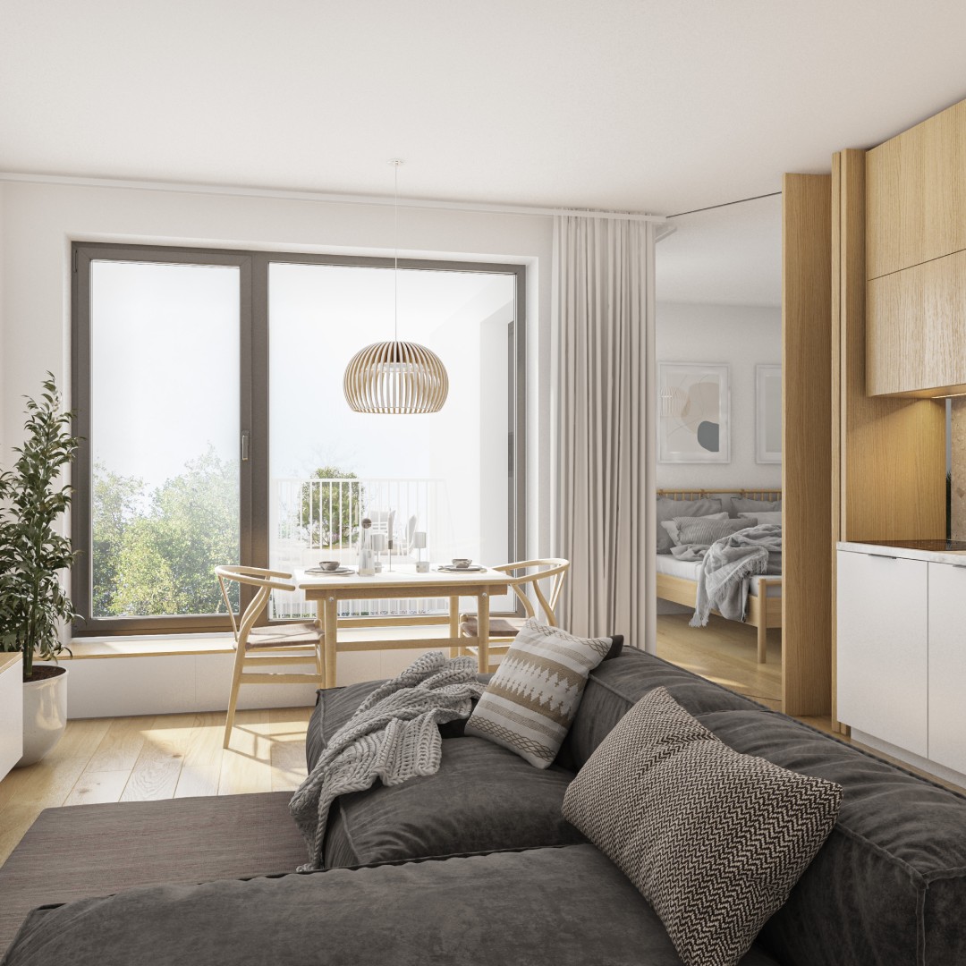 A small apartment with an oversized gray sectional in the center of the living space. A dining set sits by the window.