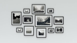A white wall displaying several photo frames in an organized manner with a matching style and color palette.