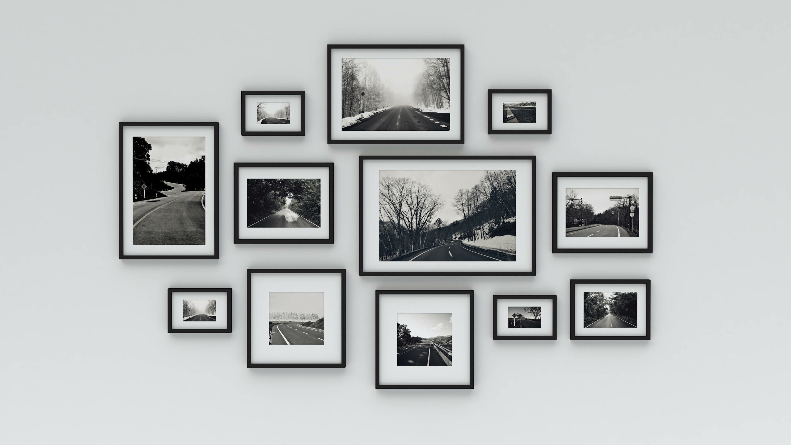 A white wall displaying several photo frames in an organized manner with a matching style and color palette.